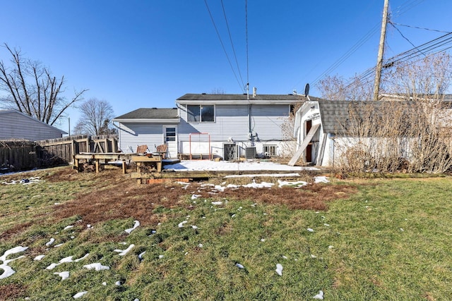 back of property with a wooden deck and a lawn