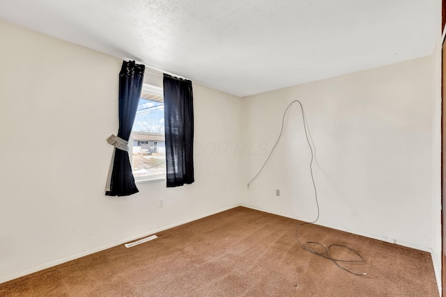 carpeted spare room featuring a textured ceiling