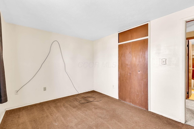 unfurnished bedroom featuring a closet and carpet flooring