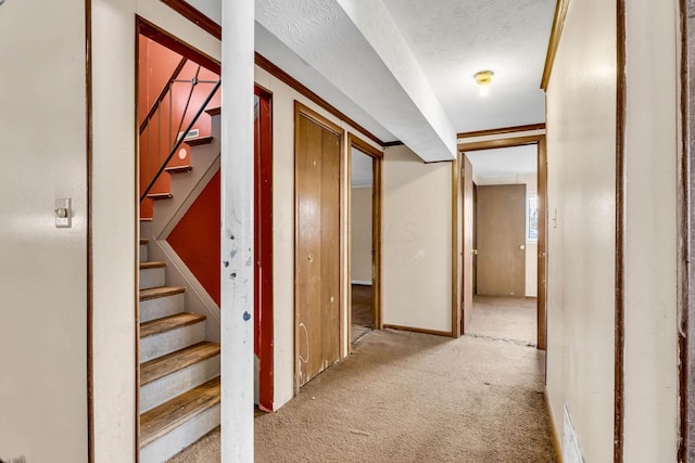 corridor with light carpet and a textured ceiling