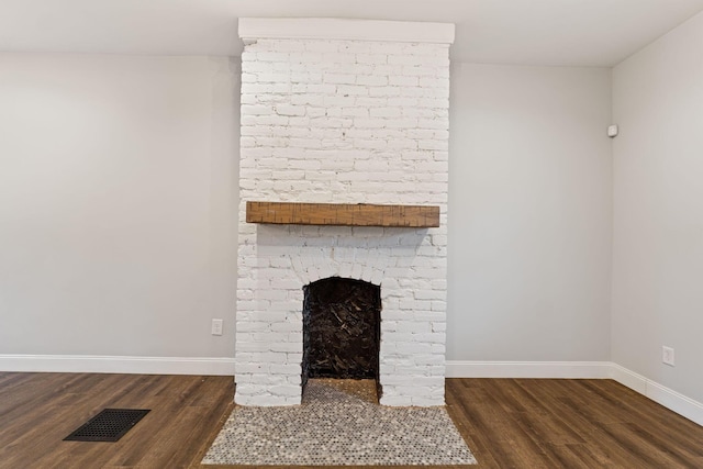 room details featuring a brick fireplace and hardwood / wood-style flooring