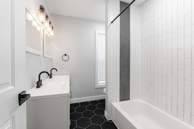 full bathroom with vanity, tiled shower / bath combo, tile patterned floors, and toilet