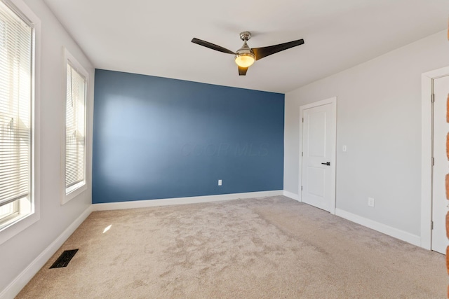 carpeted spare room with ceiling fan