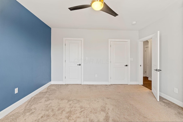 unfurnished bedroom featuring ceiling fan and light colored carpet