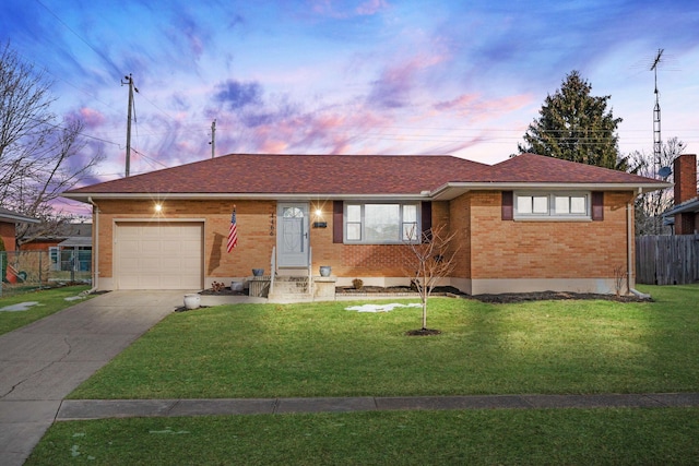 ranch-style house featuring a yard and a garage