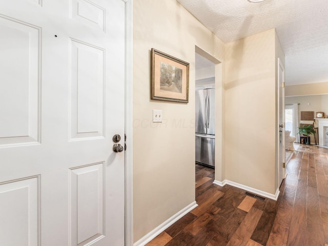 hallway featuring dark hardwood / wood-style floors and a textured ceiling