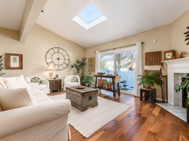 living room featuring wood-type flooring, a fireplace, and lofted ceiling with skylight