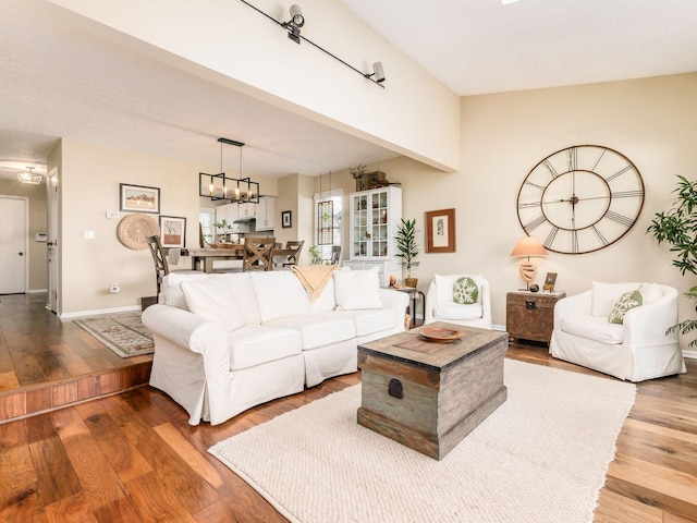 living room with a notable chandelier and wood-type flooring