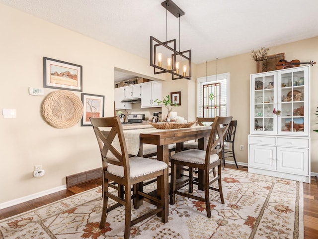 dining room with a notable chandelier, a textured ceiling, and light hardwood / wood-style flooring