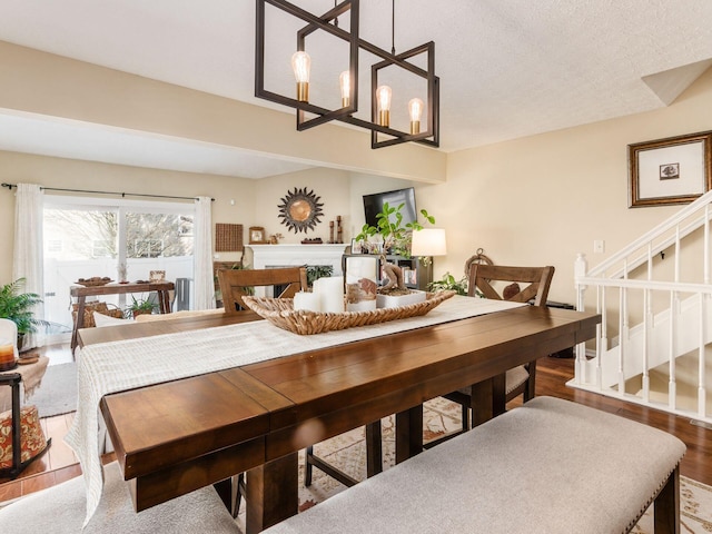 dining space with a chandelier, hardwood / wood-style floors, and a textured ceiling