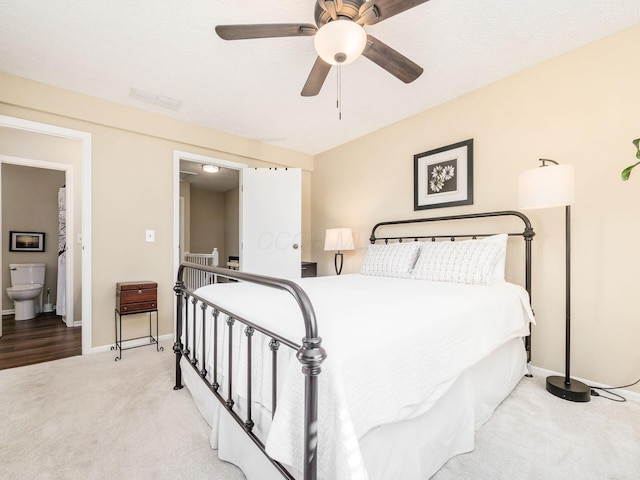 carpeted bedroom featuring ceiling fan and ensuite bath