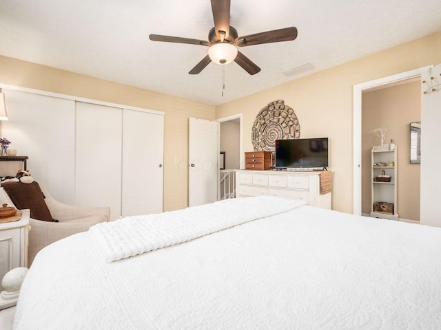 bedroom with ceiling fan and a closet