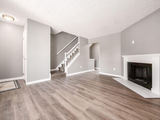 unfurnished living room with light hardwood / wood-style floors and a textured ceiling