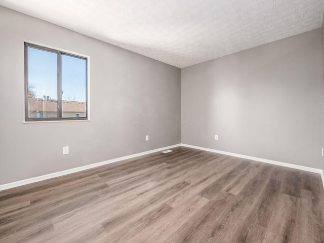 unfurnished room featuring hardwood / wood-style floors and a textured ceiling