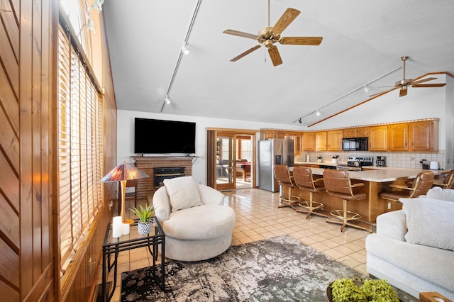 tiled living room with high vaulted ceiling, a fireplace, and ceiling fan