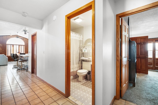 hall featuring light colored carpet and a textured ceiling