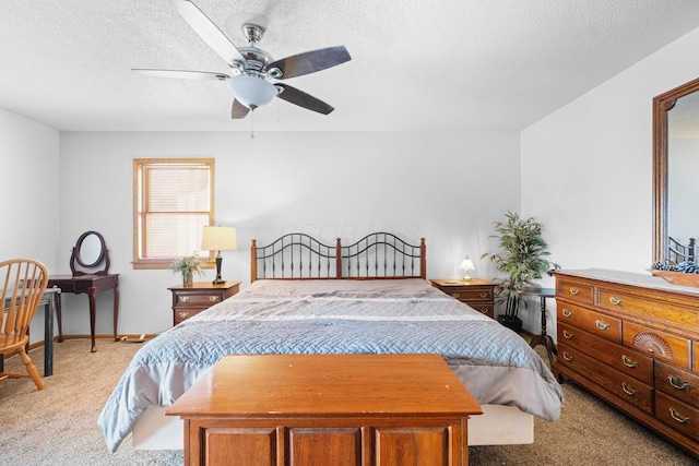 bedroom featuring ceiling fan, light colored carpet, and a textured ceiling