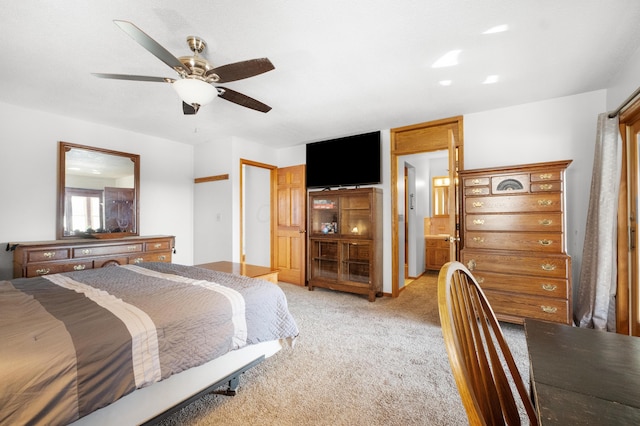 carpeted bedroom with ceiling fan and ensuite bath