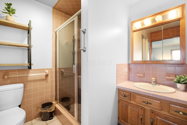 bathroom with walk in shower, vanity, toilet, and tile patterned flooring