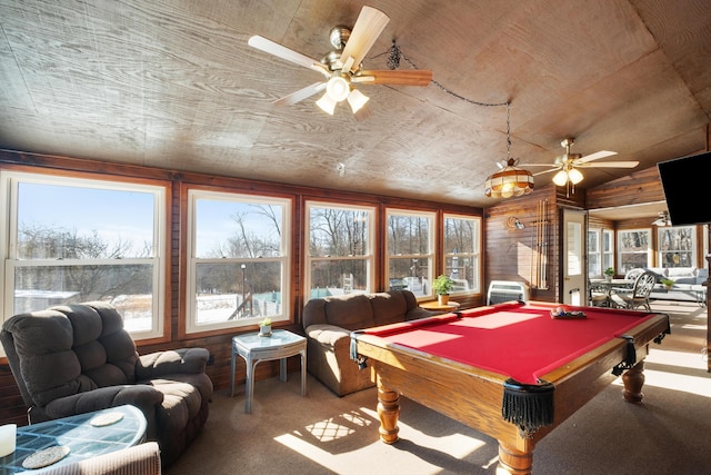 recreation room featuring a healthy amount of sunlight, carpet floors, and wood walls