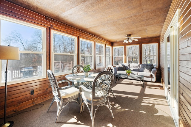 sunroom / solarium with ceiling fan, a wealth of natural light, and wood ceiling