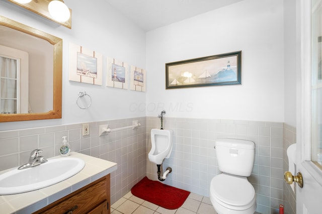 bathroom featuring tile walls, vanity, tile patterned floors, and toilet