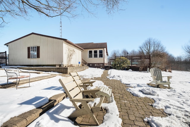 snow covered house with a wooden deck