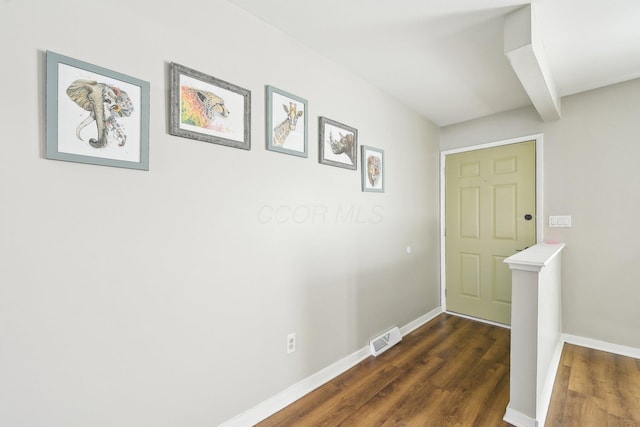 corridor with beamed ceiling and dark wood-type flooring