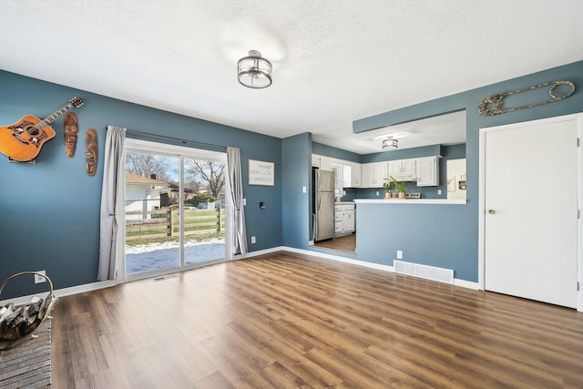 interior space with dark wood-type flooring and a textured ceiling