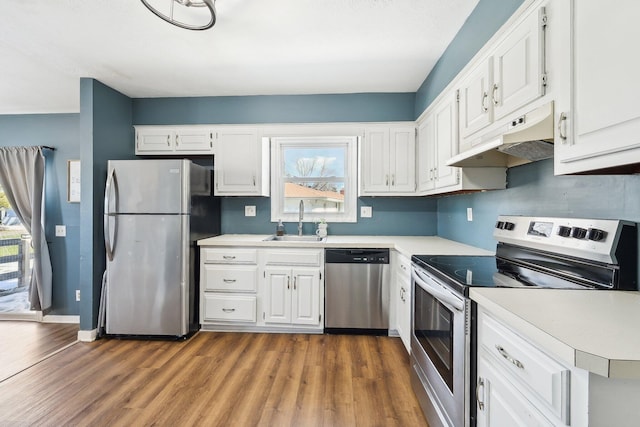 kitchen featuring stainless steel appliances, sink, dark wood-type flooring, and white cabinets