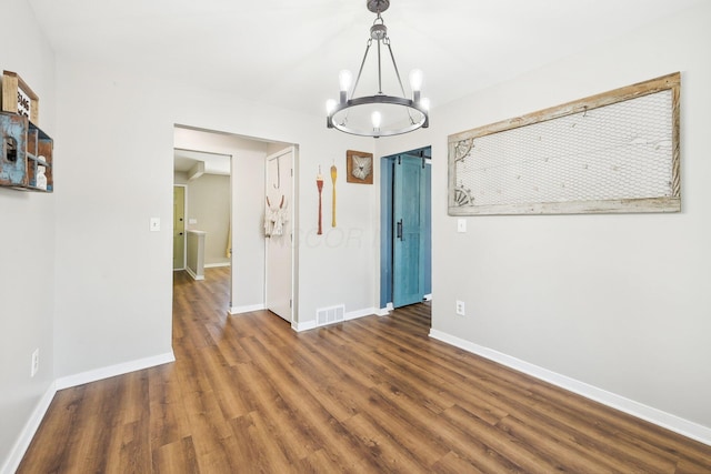 unfurnished dining area with dark hardwood / wood-style flooring and a notable chandelier