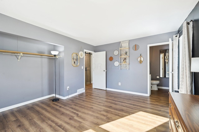 interior space with dark hardwood / wood-style floors and a barn door