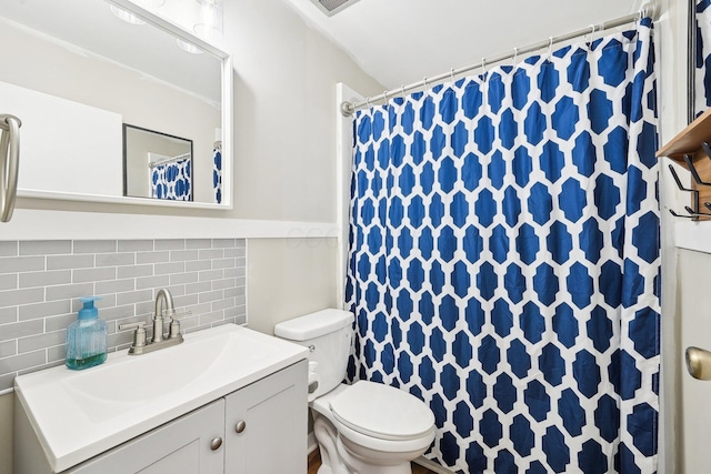 bathroom with vanity, backsplash, and toilet