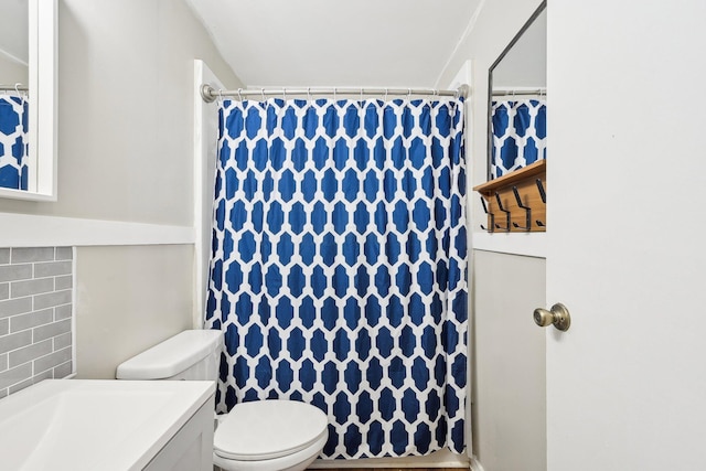 bathroom featuring vanity, backsplash, and toilet