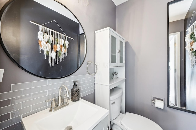 bathroom featuring tasteful backsplash, vanity, and toilet