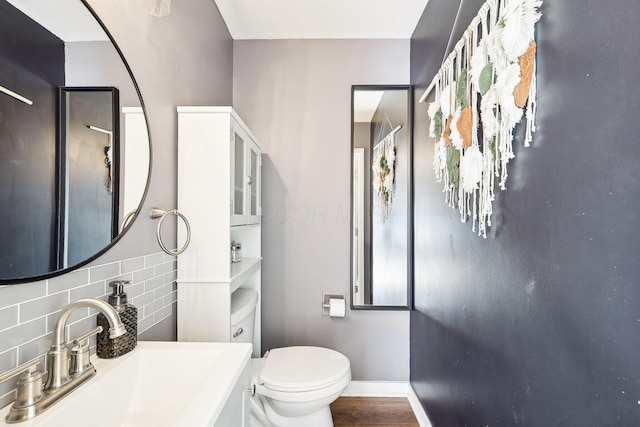 bathroom with vanity, hardwood / wood-style floors, decorative backsplash, and toilet