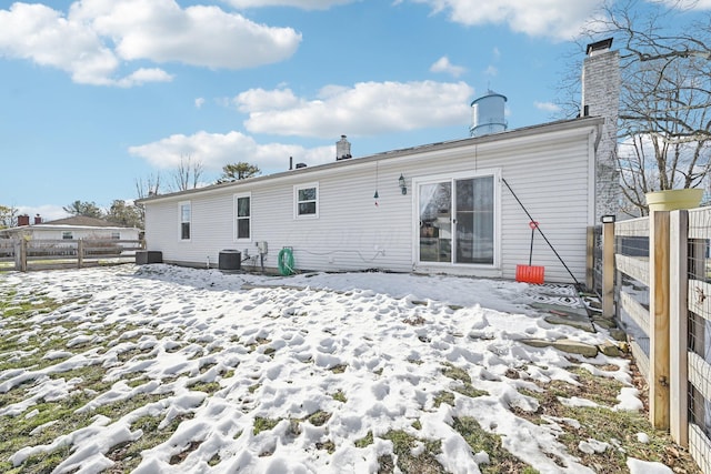 snow covered house with central air condition unit