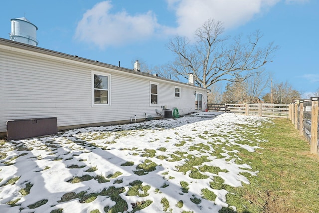 snow covered house featuring a yard