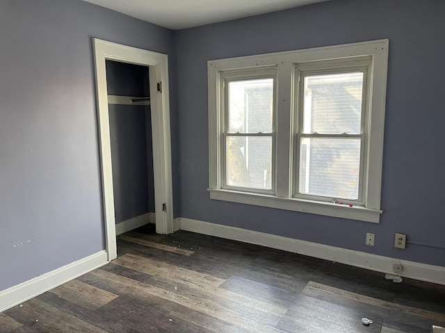 unfurnished bedroom with dark wood-type flooring