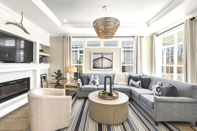 living room with crown molding, a healthy amount of sunlight, and a tray ceiling