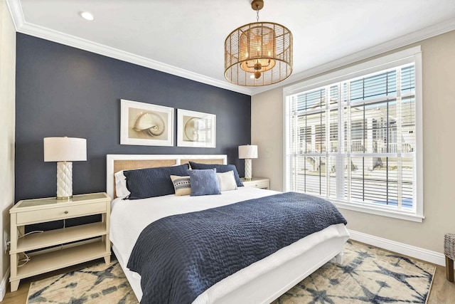 bedroom featuring ornamental molding, hardwood / wood-style floors, and a notable chandelier