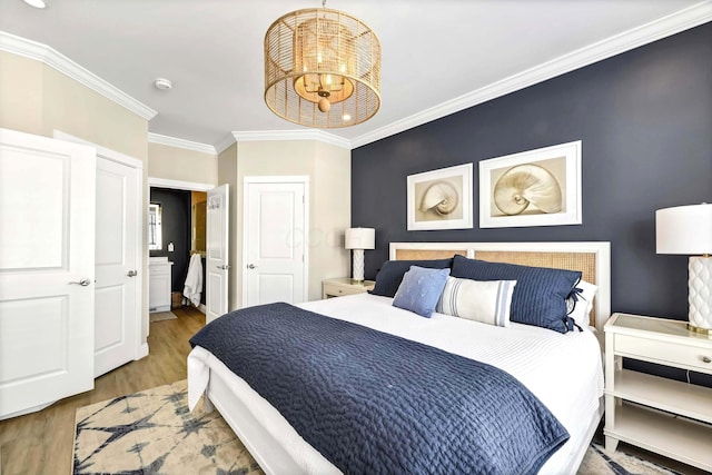 bedroom with crown molding, hardwood / wood-style flooring, and a notable chandelier