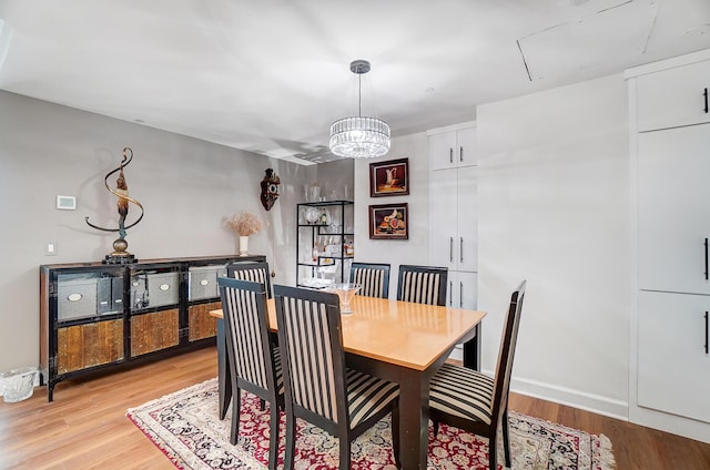 dining area with a notable chandelier and light hardwood / wood-style flooring