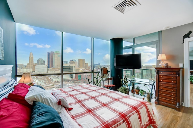 bedroom featuring expansive windows and light wood-type flooring