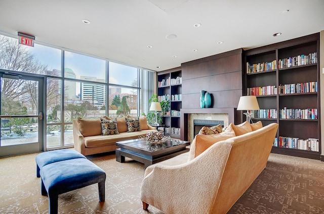 carpeted living room with built in shelves and a wall of windows