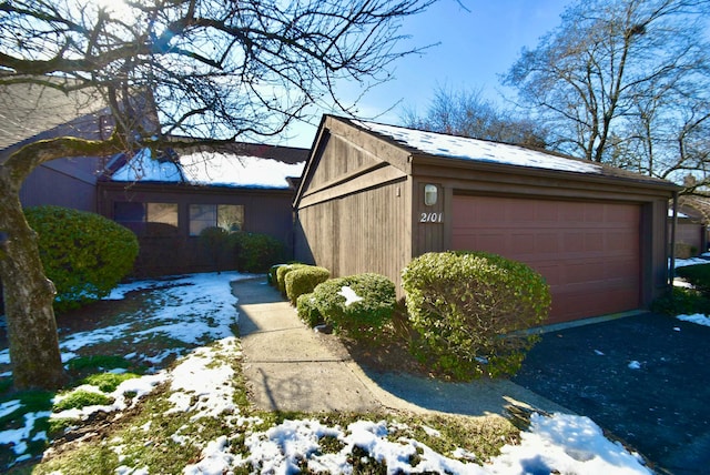 view of snowy exterior with a garage and an outdoor structure