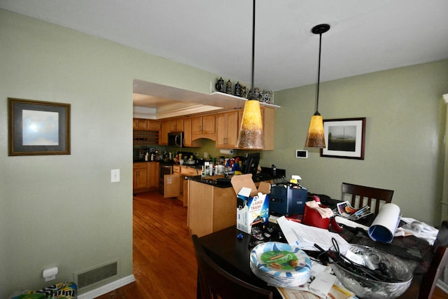 dining area with a raised ceiling and dark wood-type flooring