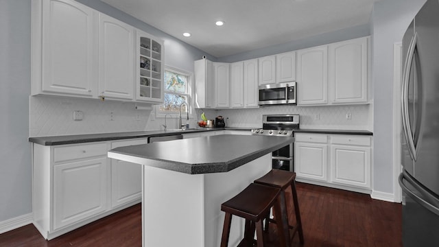 kitchen with white cabinetry, stainless steel appliances, and a center island