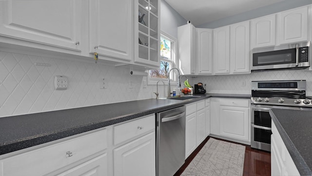 kitchen with sink, tasteful backsplash, dark hardwood / wood-style flooring, stainless steel appliances, and white cabinets