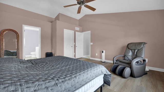 bedroom featuring ceiling fan, connected bathroom, vaulted ceiling, and hardwood / wood-style floors